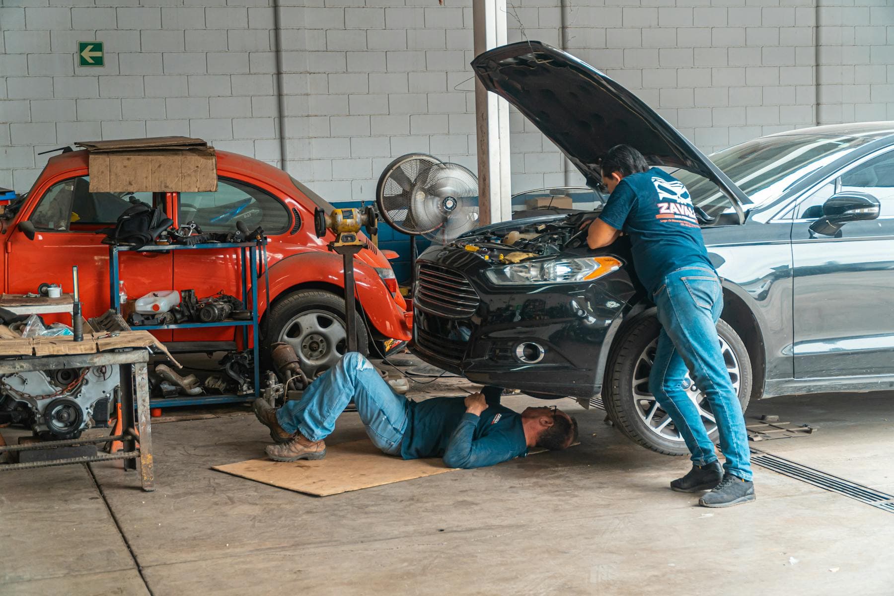 Dealership staff reviewing onboarding and training documents at a showroom desk.