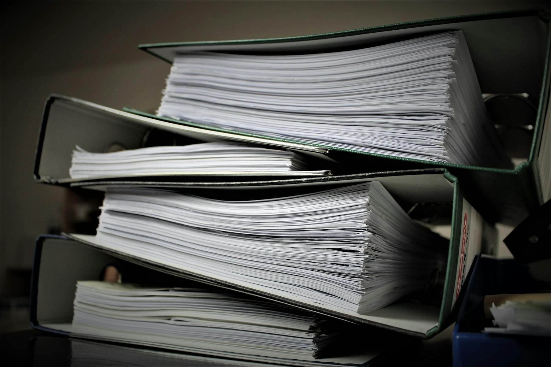 Stacked binders filled with preserved source documents.
